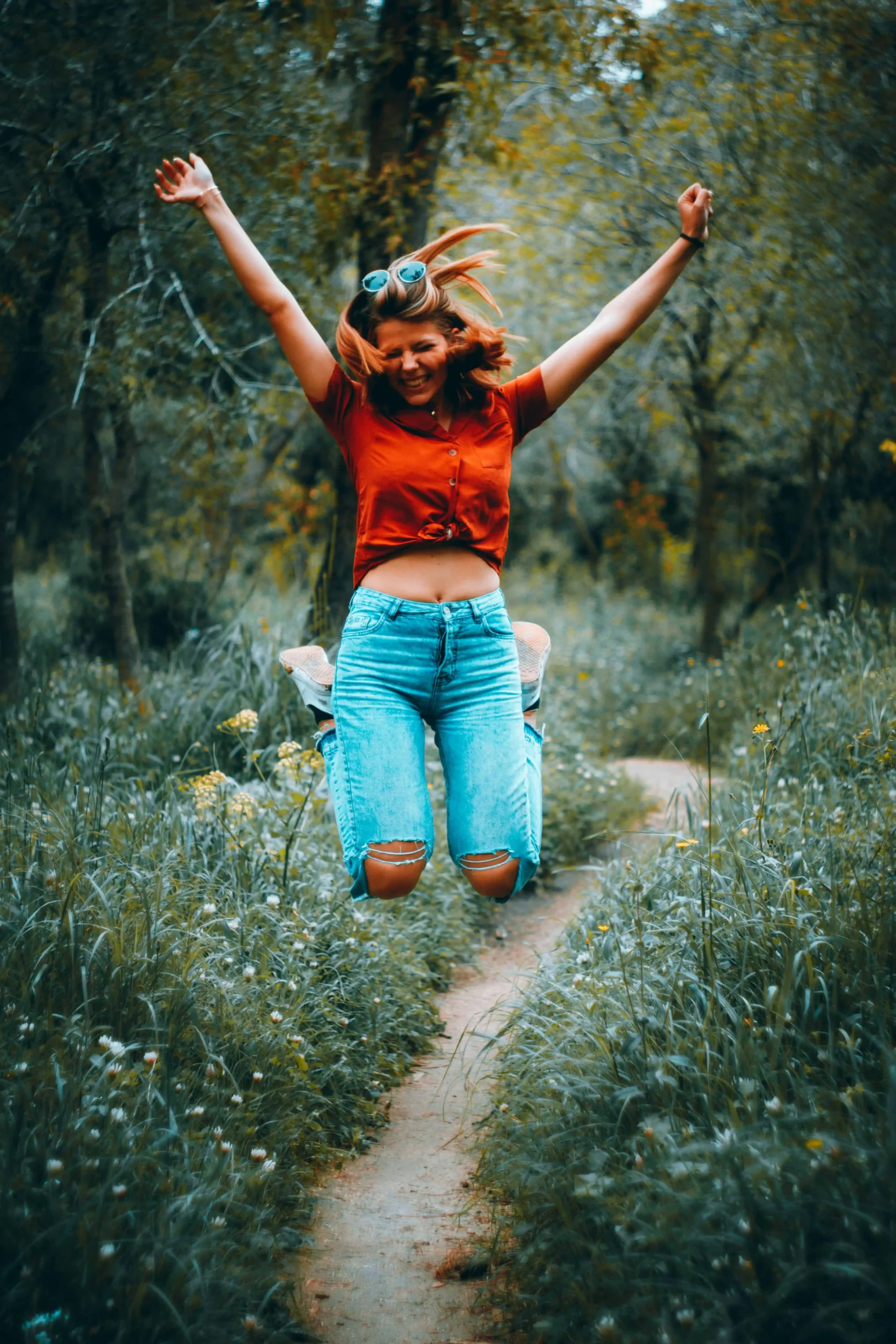 woman jumping in jeans in forest