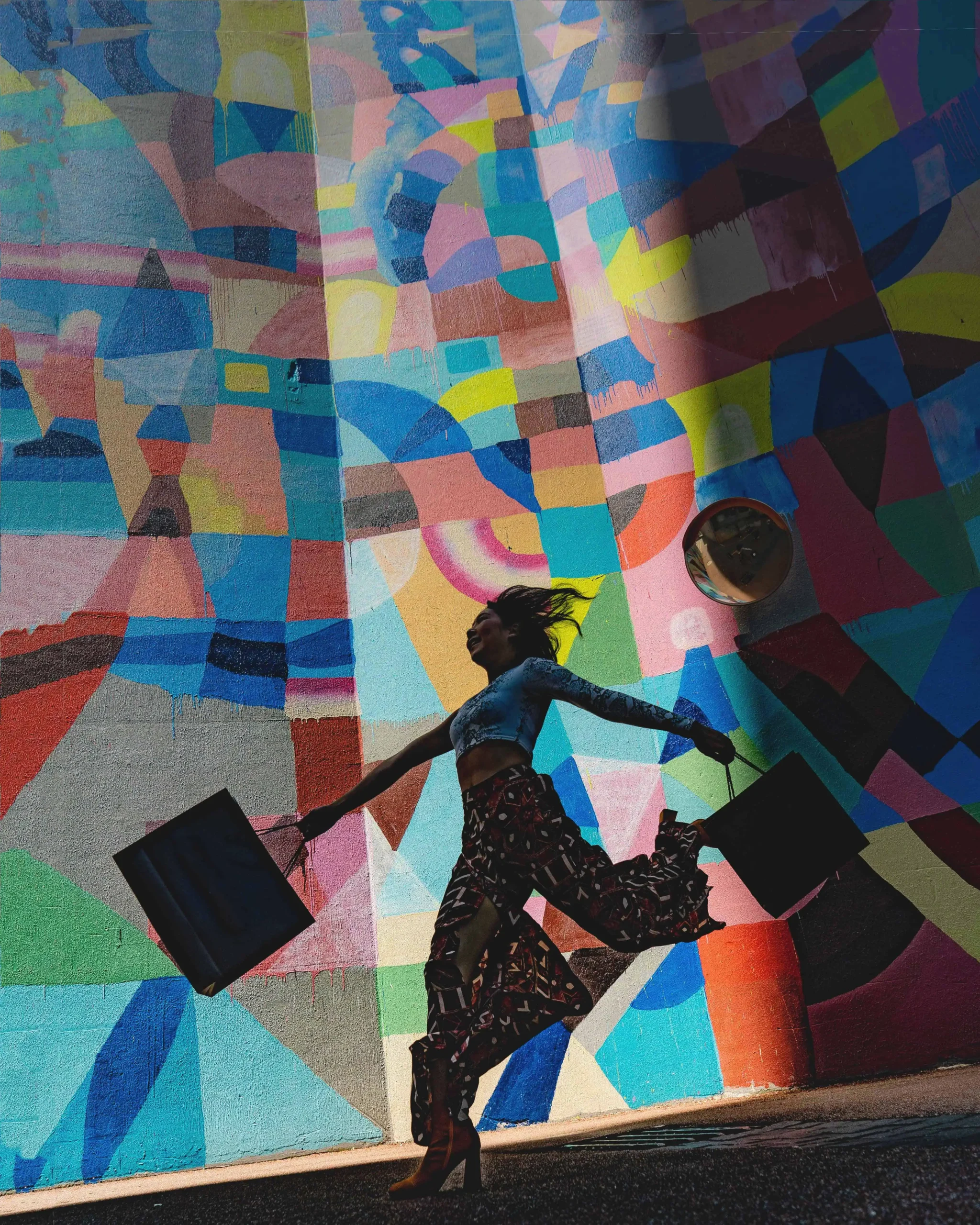 woman silhouette with shopping bags on colorfully painted wall backdrop